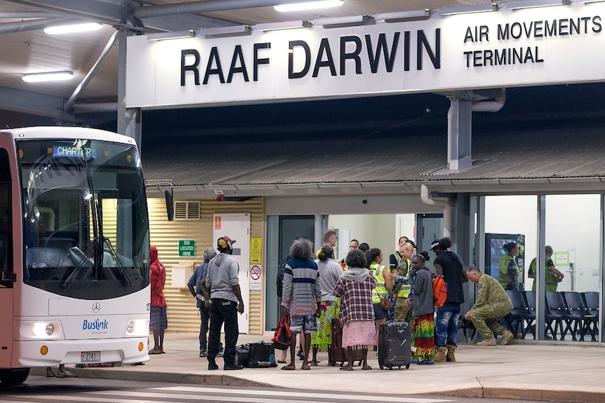 A group of people stand outside the terminal