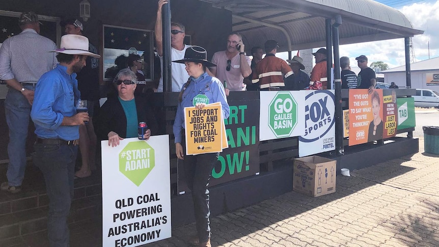 Clermont locals who support Adani's Carmichael coal mine project gather at a pub with signs against protesters.