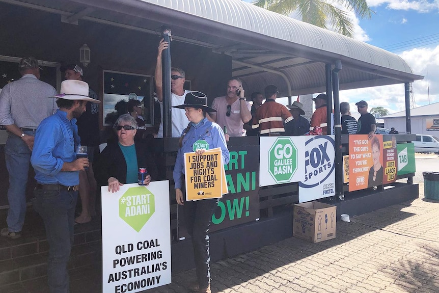 Clermont locals who support Adani's Carmichael coal mine project gather at a pub with signs against protesters.