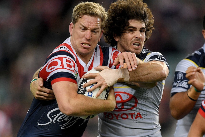 Mitchell Aubusson of the Roosters is tackled by Jake Granville of the Cowboys.