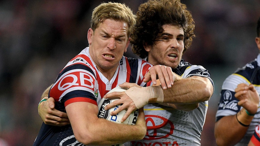 Mitchell Aubusson of the Roosters is tackled by Jake Granville of the Cowboys.