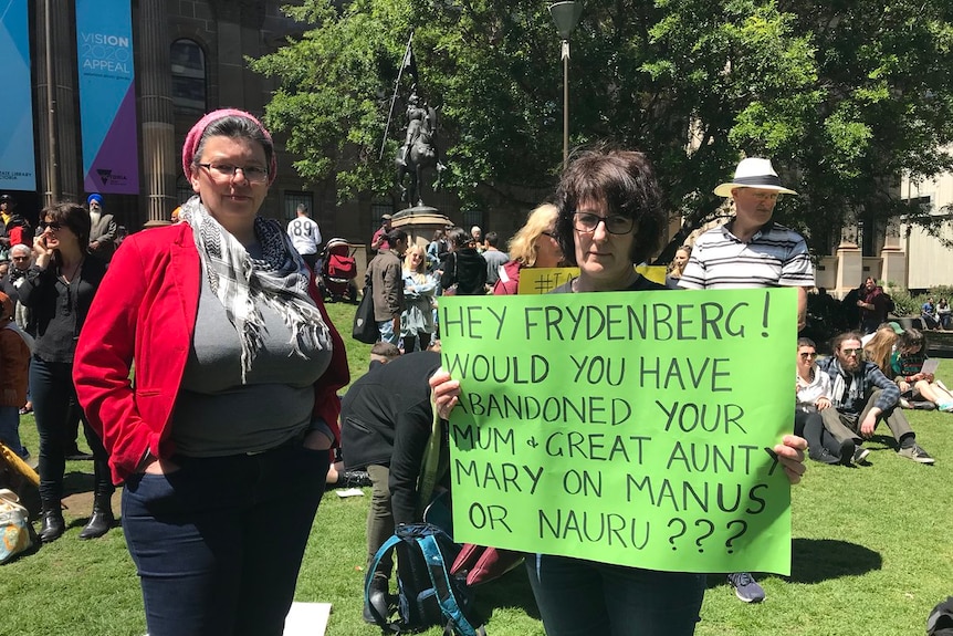 Two women hold a sign at rally in Melbourne protesting against the treatment of men on Manus Island.