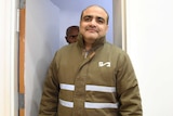 Mohammed El Halabi, director of the Gaza branch of World Vision, wearing a green jacket in a court room.