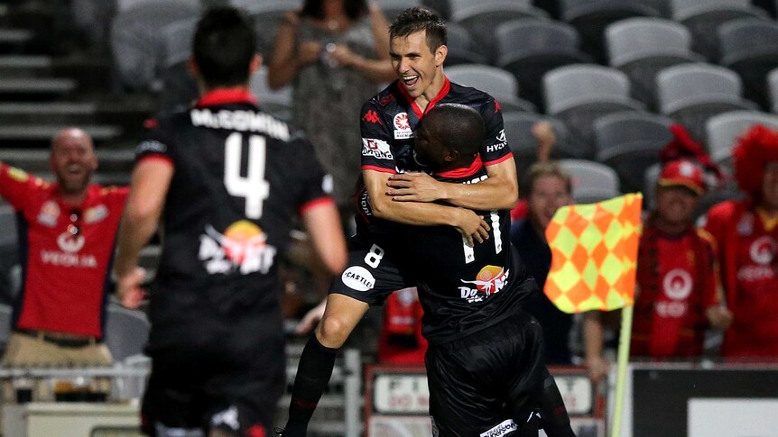Adelaide United celebrate a goal from Isaias Sanchez (C) against Central Coast in Gosford.