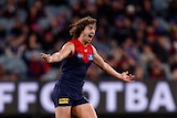 A man celebrates a goal during an AFL match