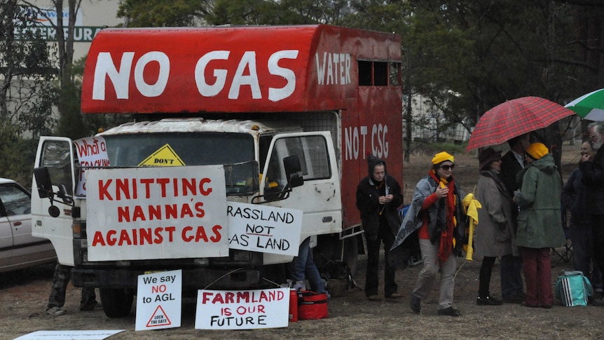 People protesting a coal seam gas project in the Gloucester Valley in New South Wales display signs with anti-CSG slogans.
