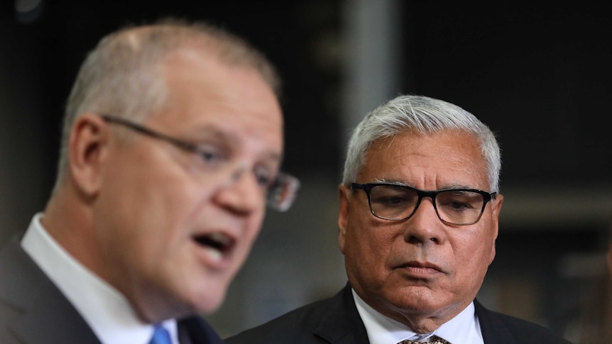 Warren Mundine watches on as Scott Morrison speaks at a press conference