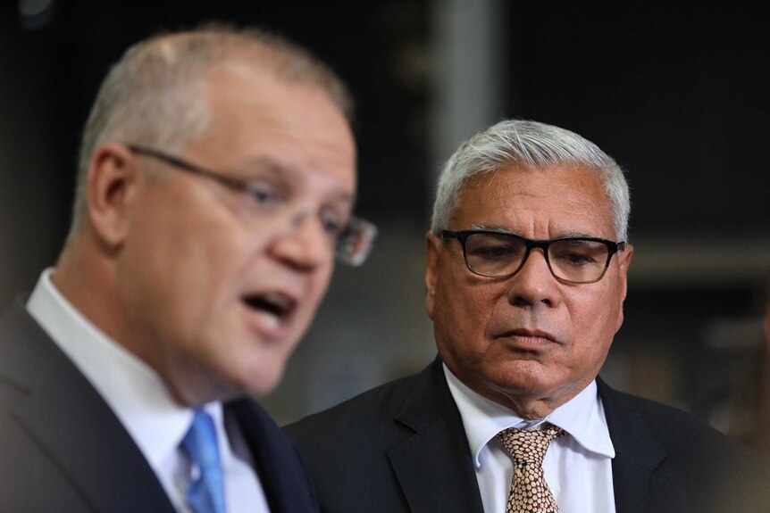 Warren Mundine watches on as Scott Morrison speaks at a press conference
