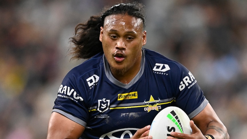 A North Queensland Cowboys NRL player holds the ball during a match in 2022.