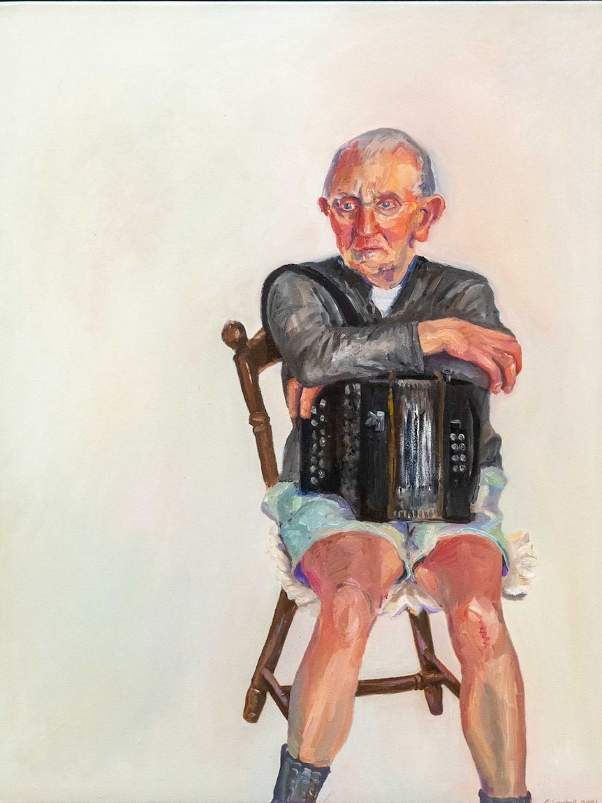 A beautiful, simple portrait of an older man sitting on a chair holding his squeeze box