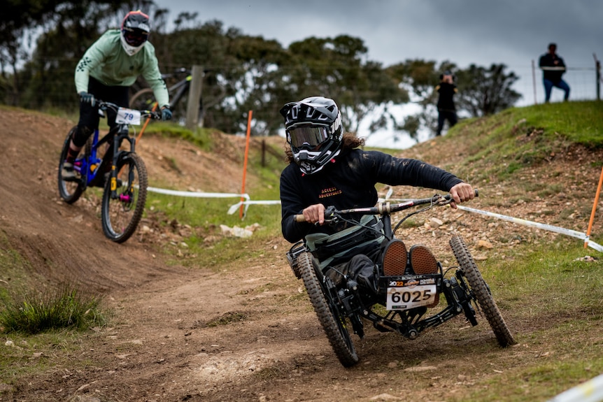 A man riding on a three-wheel bike down a hill