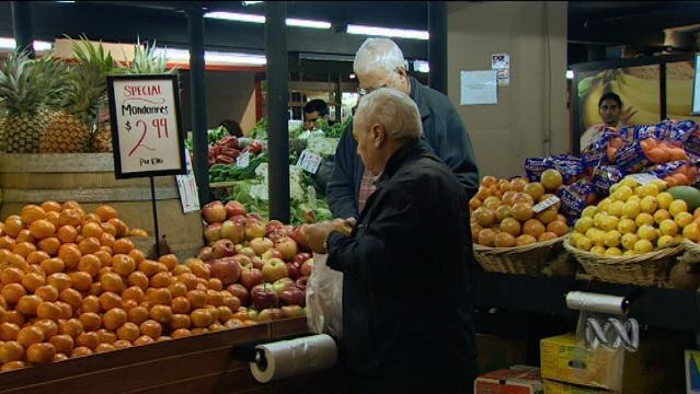 Elderly man stands at fruit market