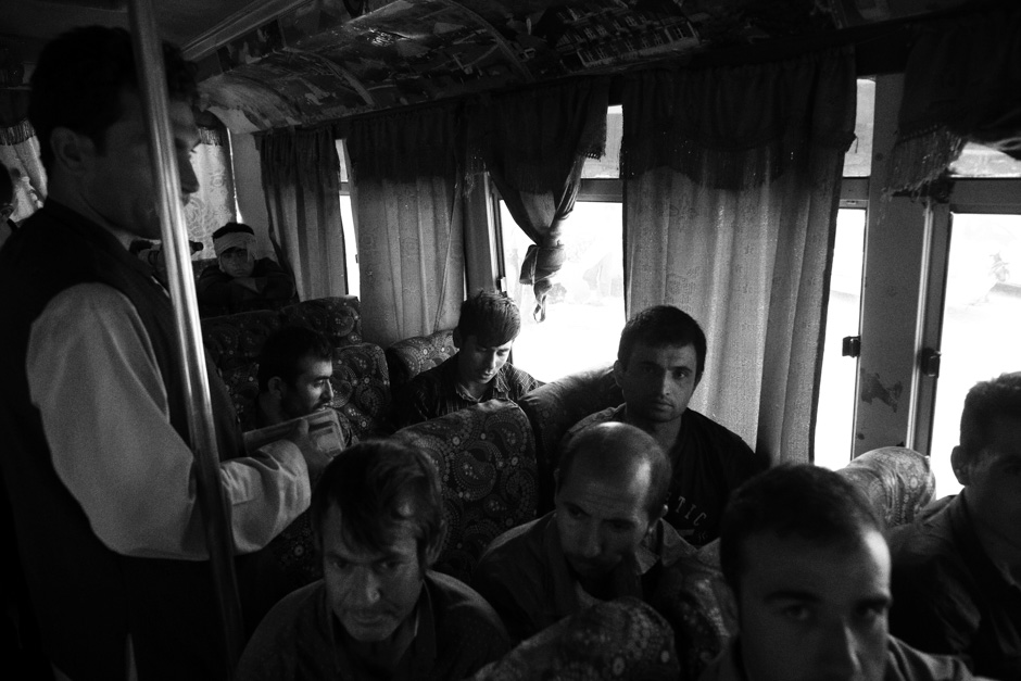 Afghan men - the majority of them just deported from Iran - aboard a bus on the Afghan side of the border, bound for Herat.