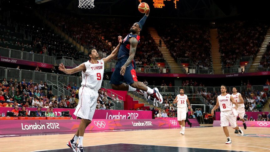 LeBron James dunks over Mohamed Hadidane during the USA v Tunisia match at the London Olympic Games.