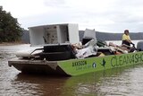 A man drives a barge full of debris