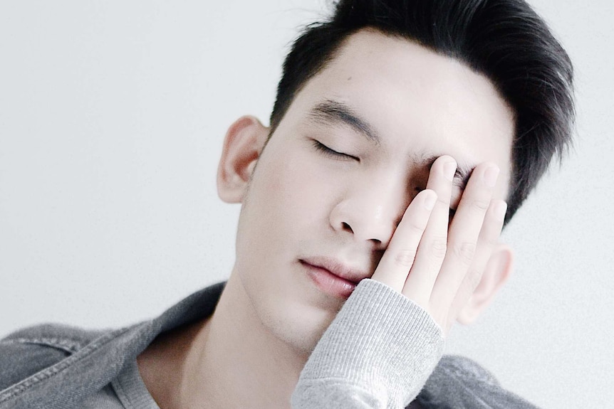 Closeup of man with his eyes closed and a hand resting on his face representing time saving, simple skincare routines