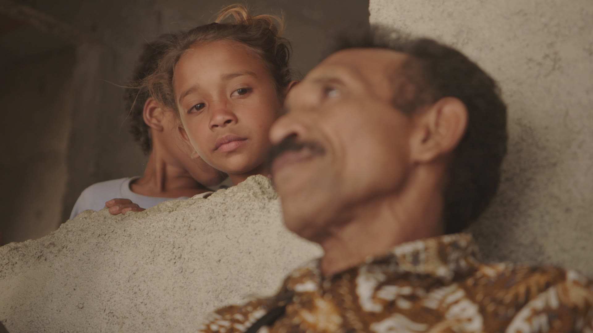 Children in Ainaro watch on as Alis is welcomed home.