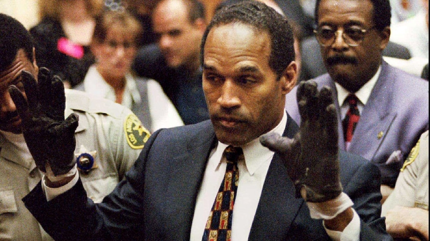 OJ simpson in court wearing black gloves with his hands up showing the jury