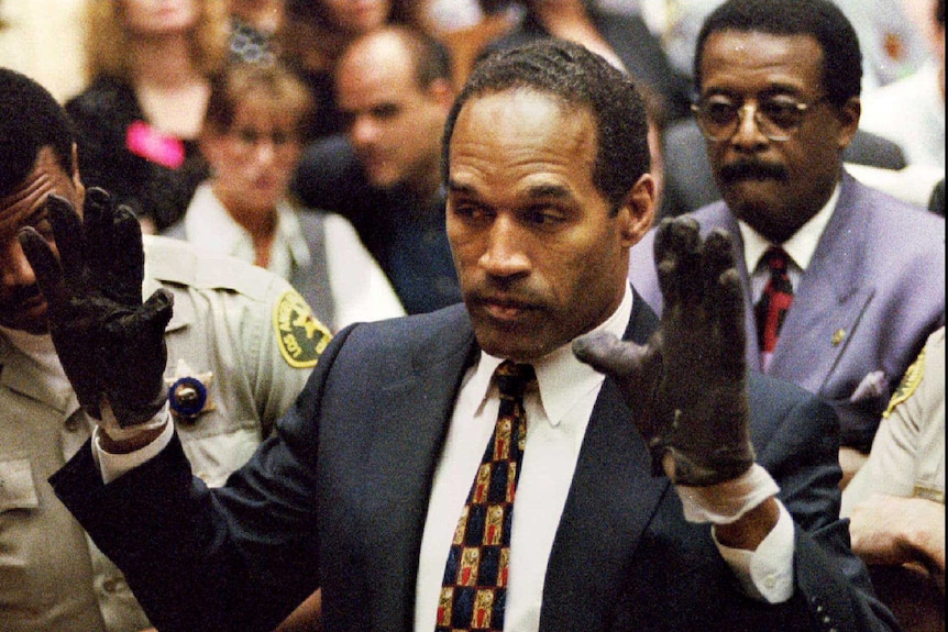 OJ simpson in court wearing black gloves with his hands up showing the jury