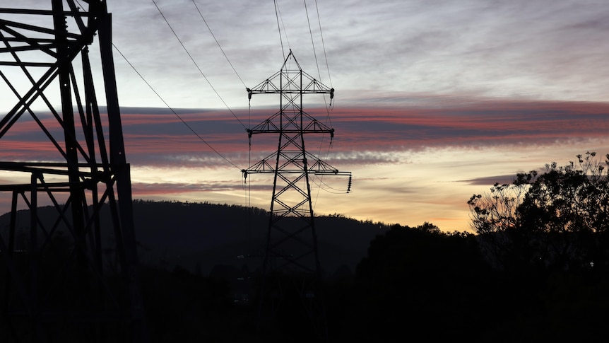 Silhouette of an electricity transmission tower at dawn.