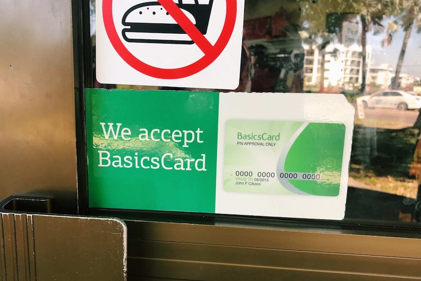 A sign saying "We accept Basics Card" hangs on the window