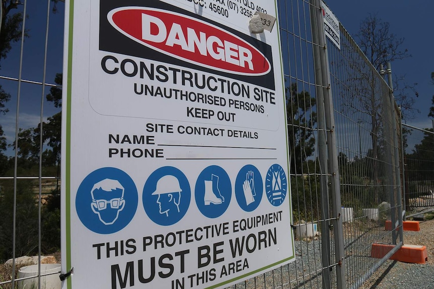 Danger sign on fence at house construction site.