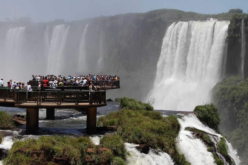 Tourists look at Iguazu Falls from an observation platform at the Iguazu National Park