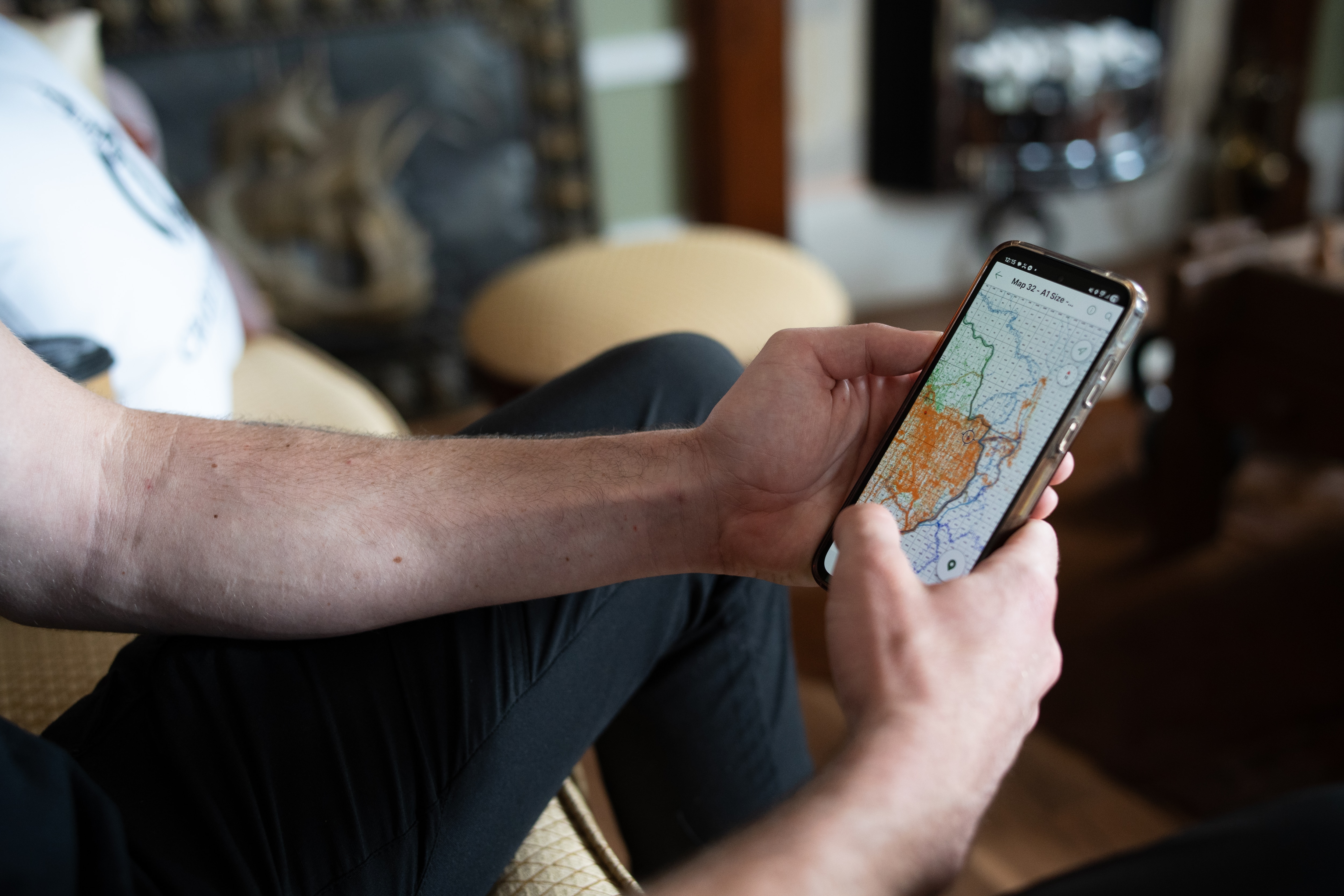 Telefone inteligente nas mãos do homem, com mapa na tela.