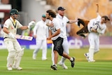 Protesters and cricketers tangle while orange smoke fills the air