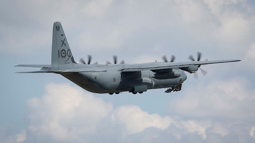 A big military aircraft flies through the sky,