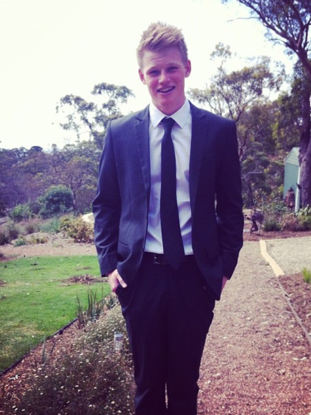 A young man wears a suit and tie.