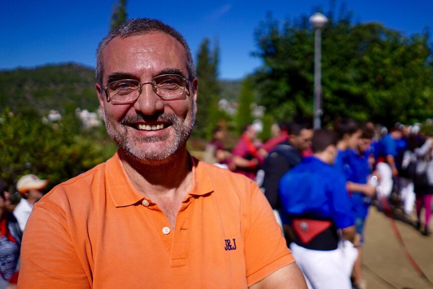 A middle aged Catalan man smiles into the camera