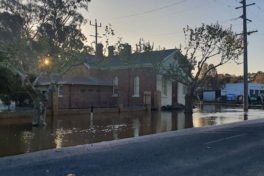 An old red brick building surrounded by water