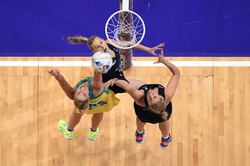Caitlin Bassett of Australia competes for a rebound with Casey Kopua and Katrina Grant