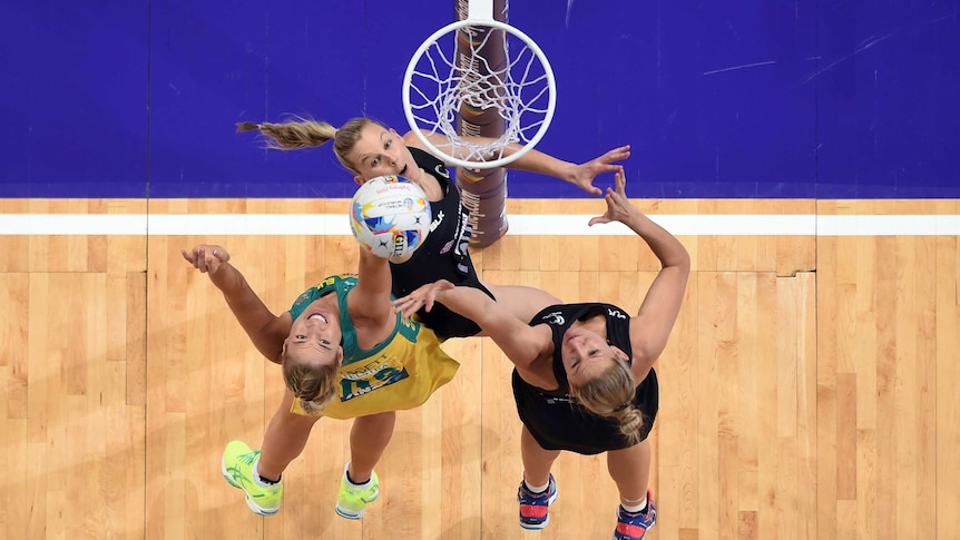 Caitlin Bassett of Australia competes for a rebound with Casey Kopua and Katrina Grant