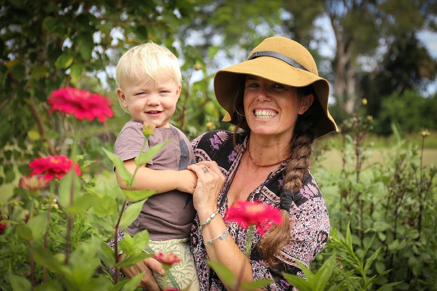 Hannah Lea Robertson holds her son Albie amongst field of flowers