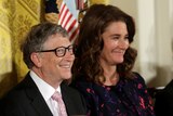 Bill Gates smiles at the camera while Melinda Gates smiles, looking in another direction. 