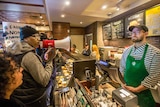 Black Lives Matter activist Asa Khalif yells at a Starbucks employee with a megaphone.