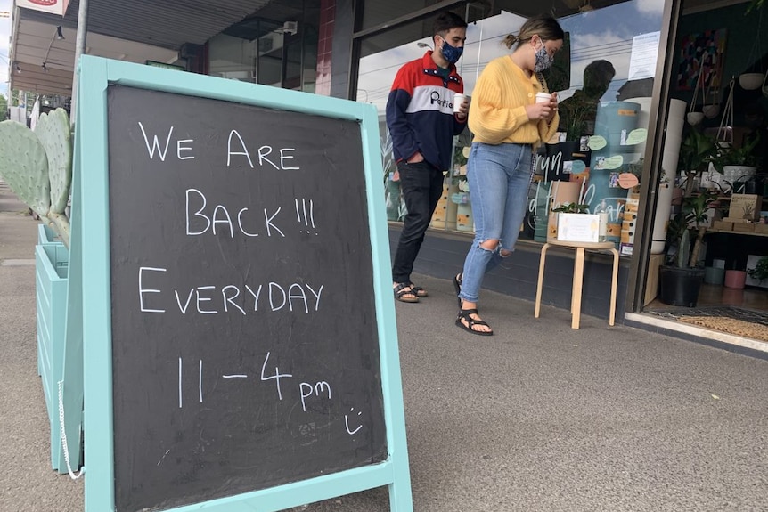 A chalkboard bears a welcome message outside a business.