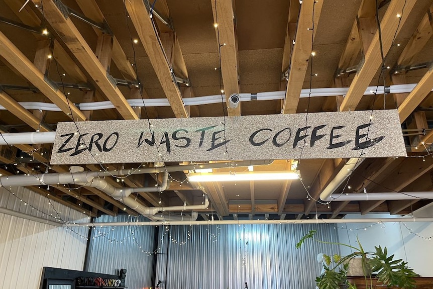 A sign hanging above a cafe that says 'zero waste coffee'