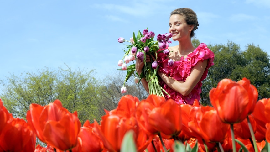 Floriade ambassador Rachael Finch smells the flowers at the launch of Floriade in Canberra.