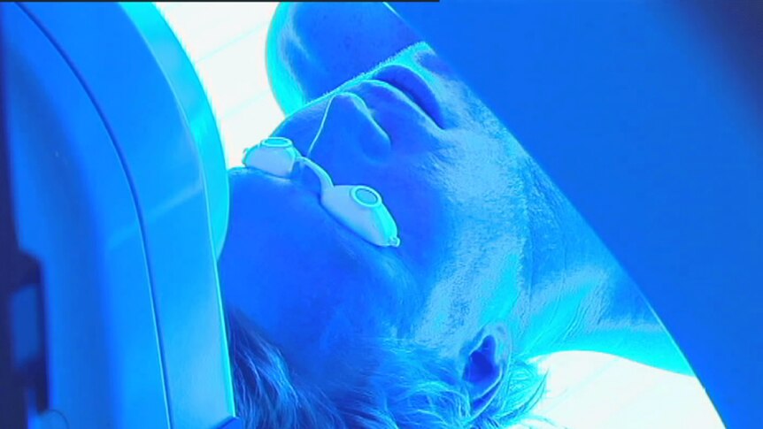 Man with goggles in a UV tanning machine