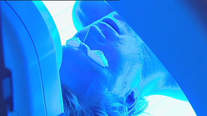 Man with goggles in a UV tanning machine