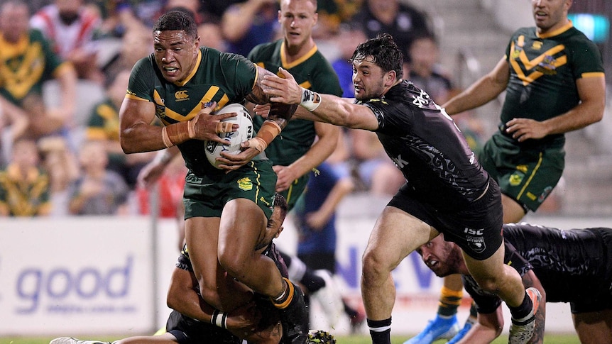 Tyson Frizell evades a number of New Zealand tacklers while running with the ball.