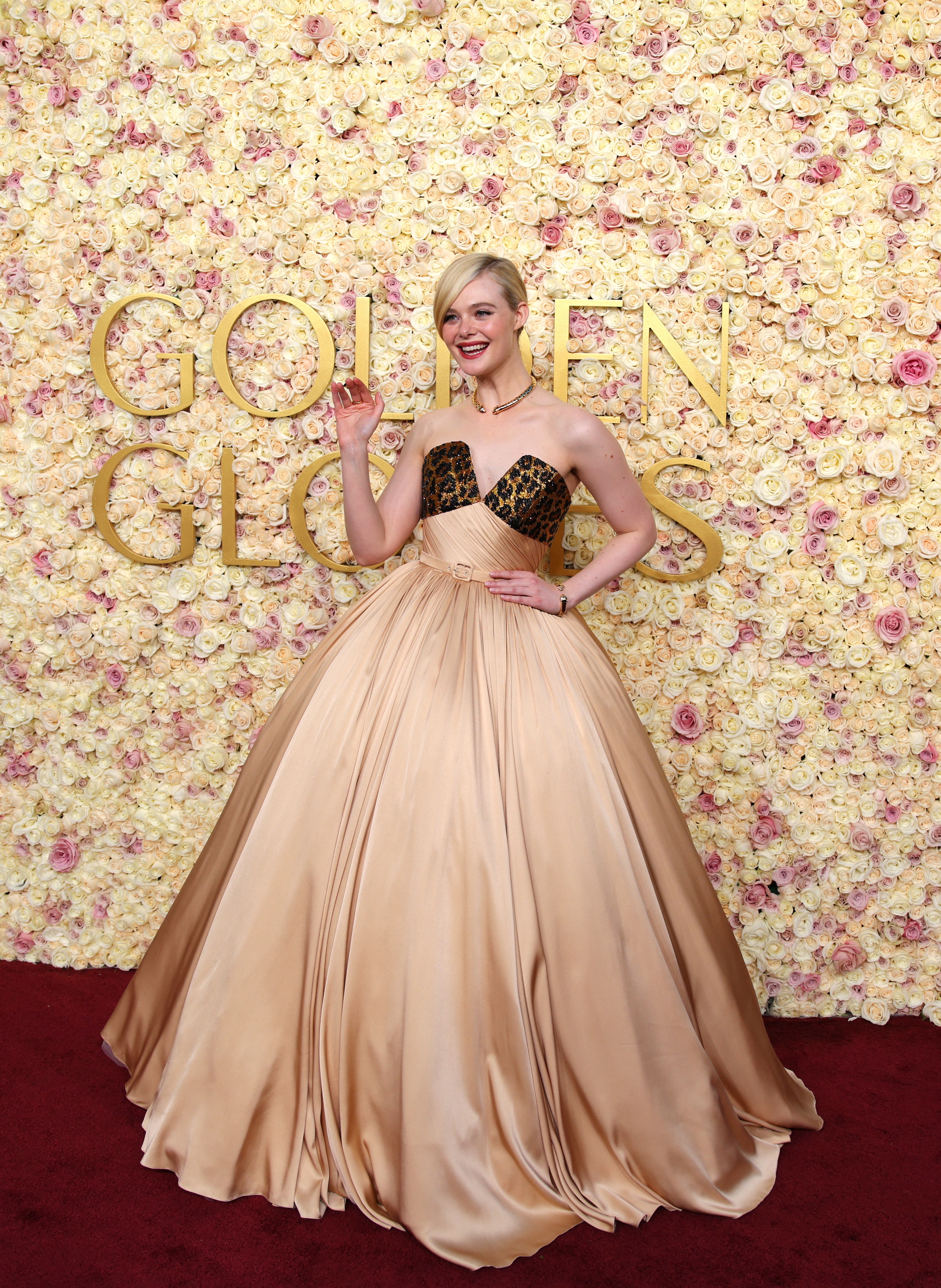 Elle Fanning wearing a light gold ballgown dress with a little bit of cheetah print