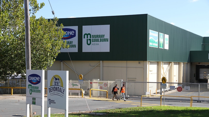 Two men walking past the Kiewa factory for Murray Goulburn