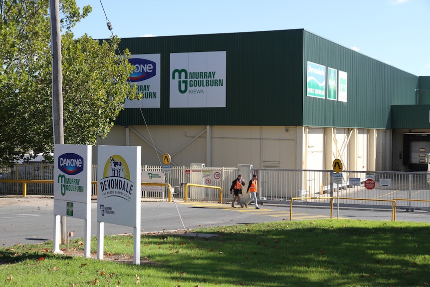 Two men walking past the Kiewa factory for Murray Goulburn