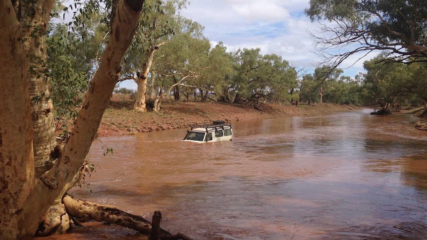 A four-wheel-drive which was washed away after the driver attempted to cross a flooded road near Santa Teresa, NT.