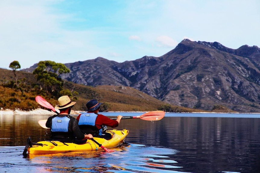 Two people canoeing on a lake in Southwest National Park in Tasmania
