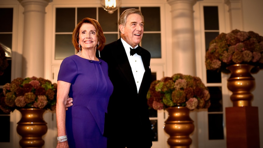 Nancy Pelosi in a purple gown and her husband Paul in a tux 